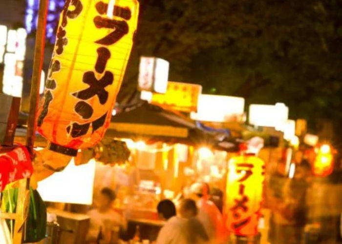 The bright lights of ramen lanterns at a yatai food stall.